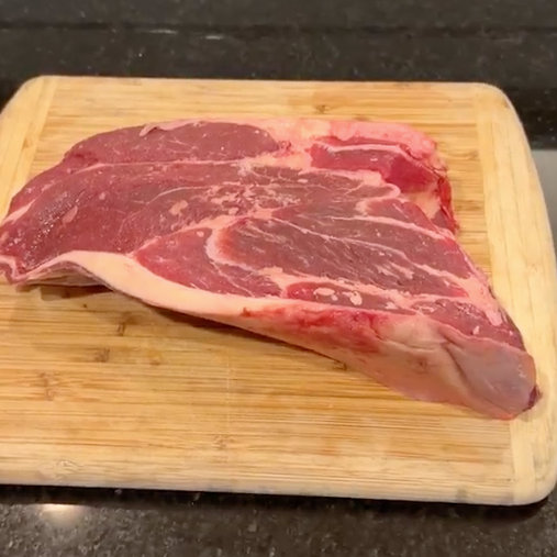 grass fed Arm Roast on a wooden cutting board